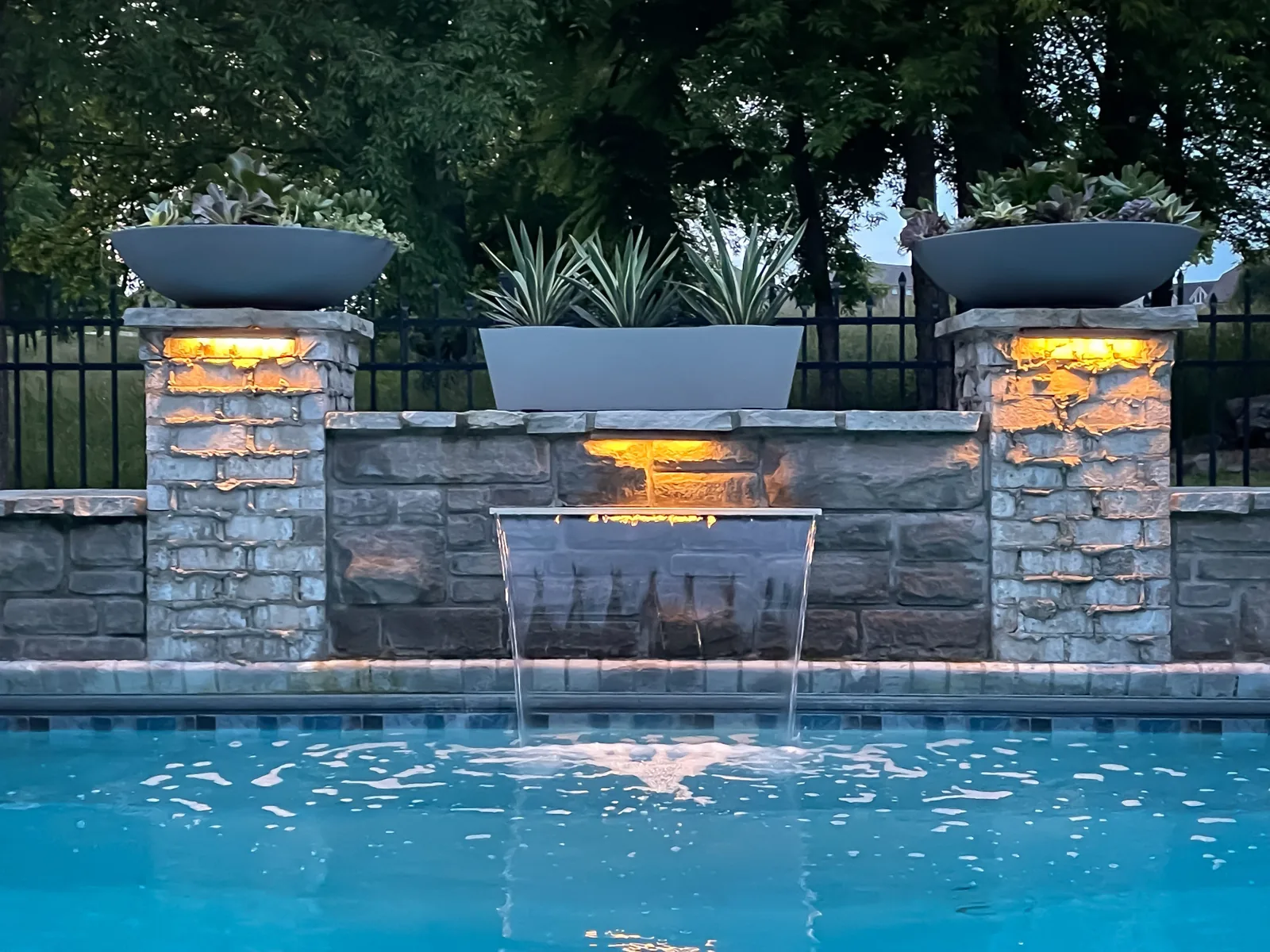 Lit stone water feature and pool spillway