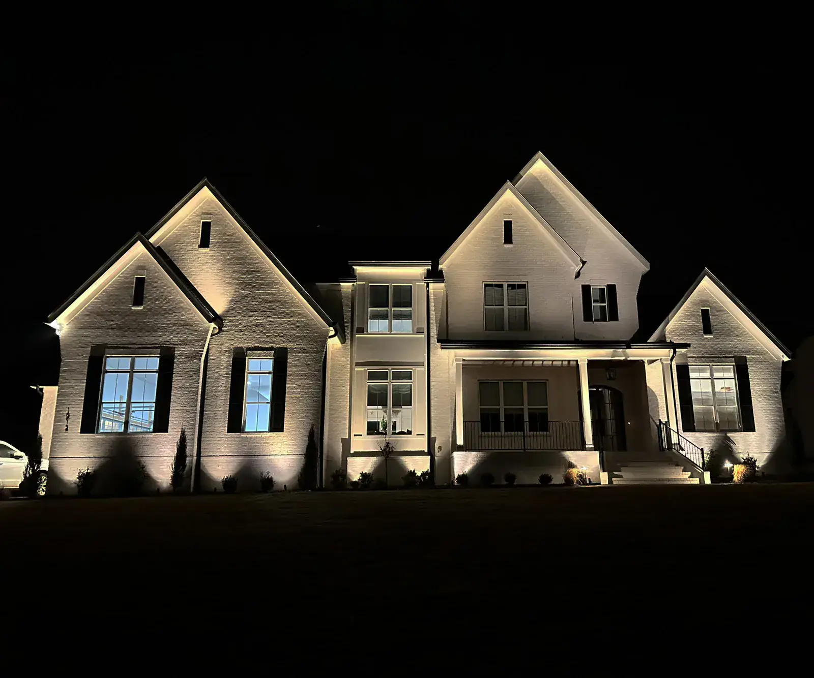 Covered porch and outdoor kitchen lit at night