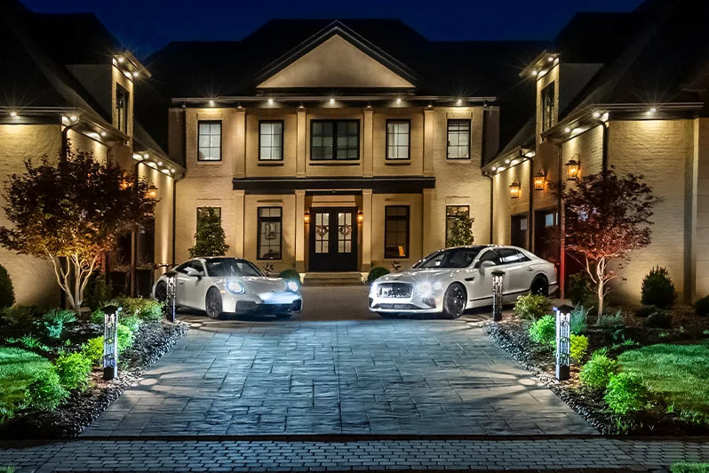A Brentwood estate fully illuminated at night with architectural and landscape lighting