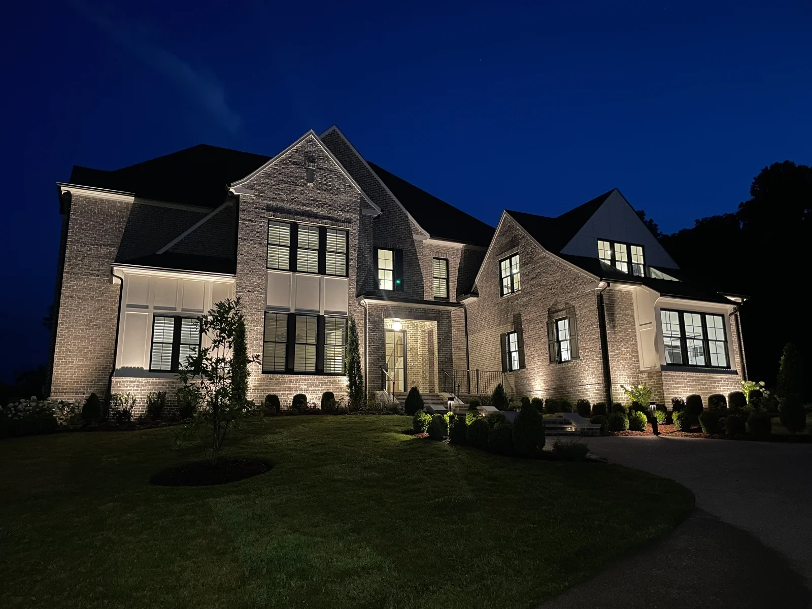Brick estate home in Brentwood, TN with full architectural and landscape uplighting at blue hour