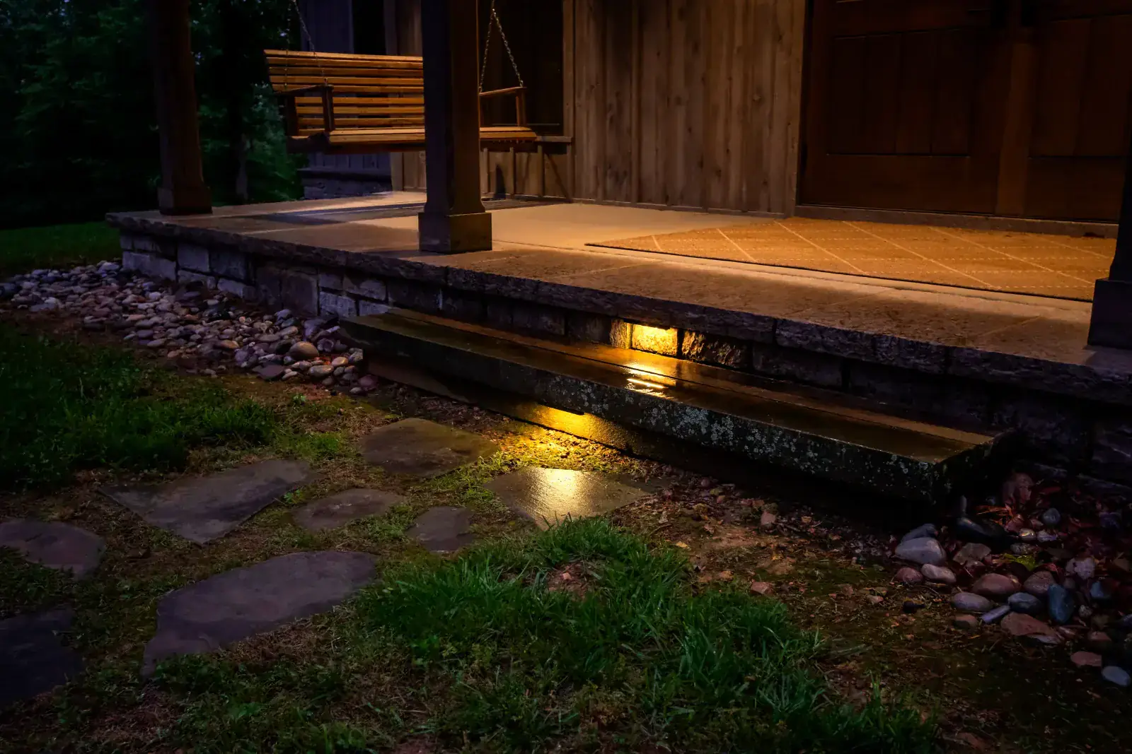 Warm step and porch lighting on a rustic farmhouse at night in Leiper's Fork