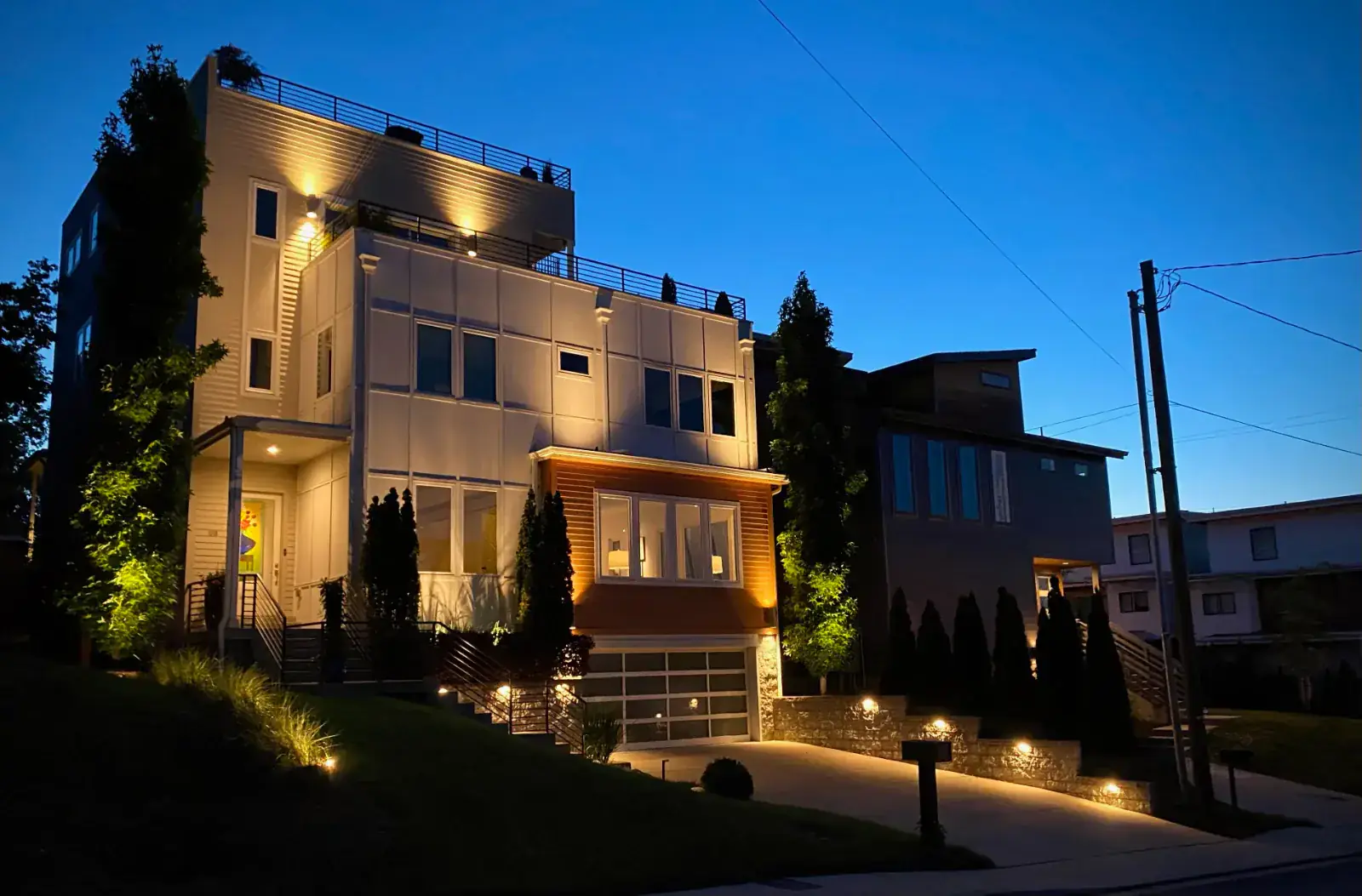 Programmable roofline and architectural lighting on a modern multi-story home at dusk