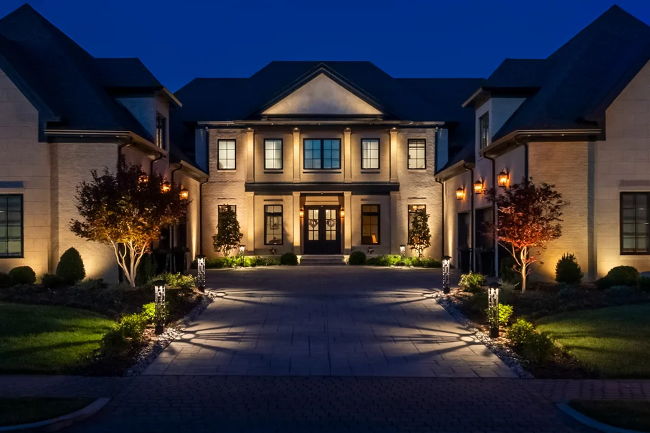 The same Hendersonville estate facade fully illuminated with landscape and architectural lighting after dark