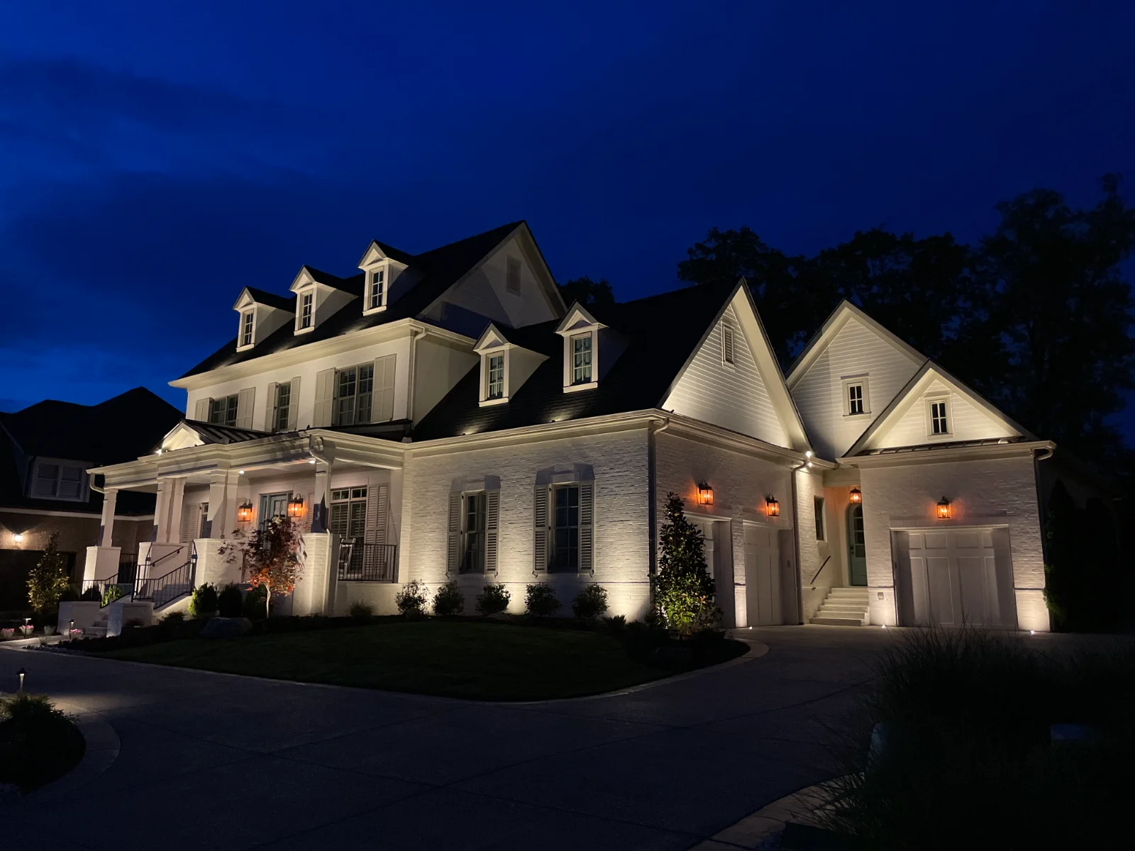 Facade lighting illuminating a white brick home at night, designed by Light TN